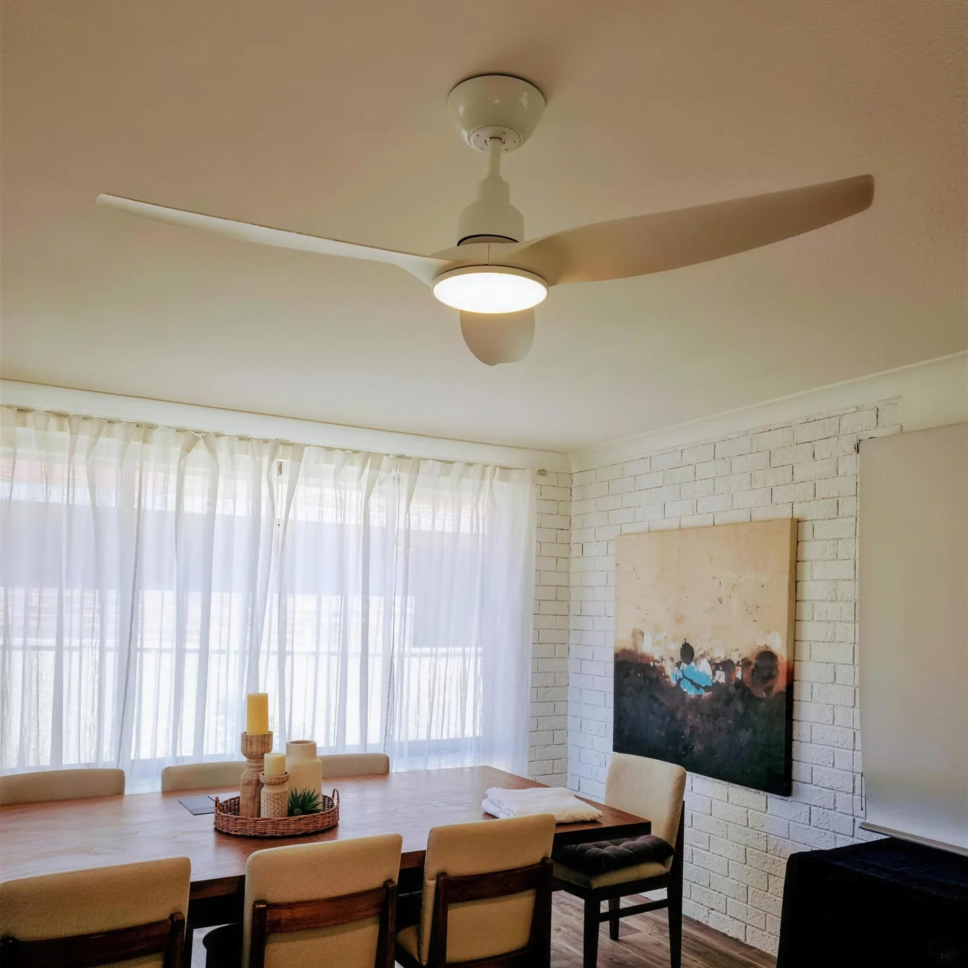 A dining room ceiling fan with an integrated light, installed on a white ceiling